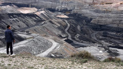 Man stares at strip mined landscape