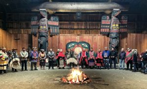 Stewardship, not greed say Kwakwaka'wakw Gig̲a̲me (Hereditary Chiefs) standing together after placing down their Coppers | Photo provided by Desiree Mannila from Gig̲a̲me Walas Namugwis' April 1, 2023 feast at the Tsakis Gukwdzi (Fort Rupert Bighouse)