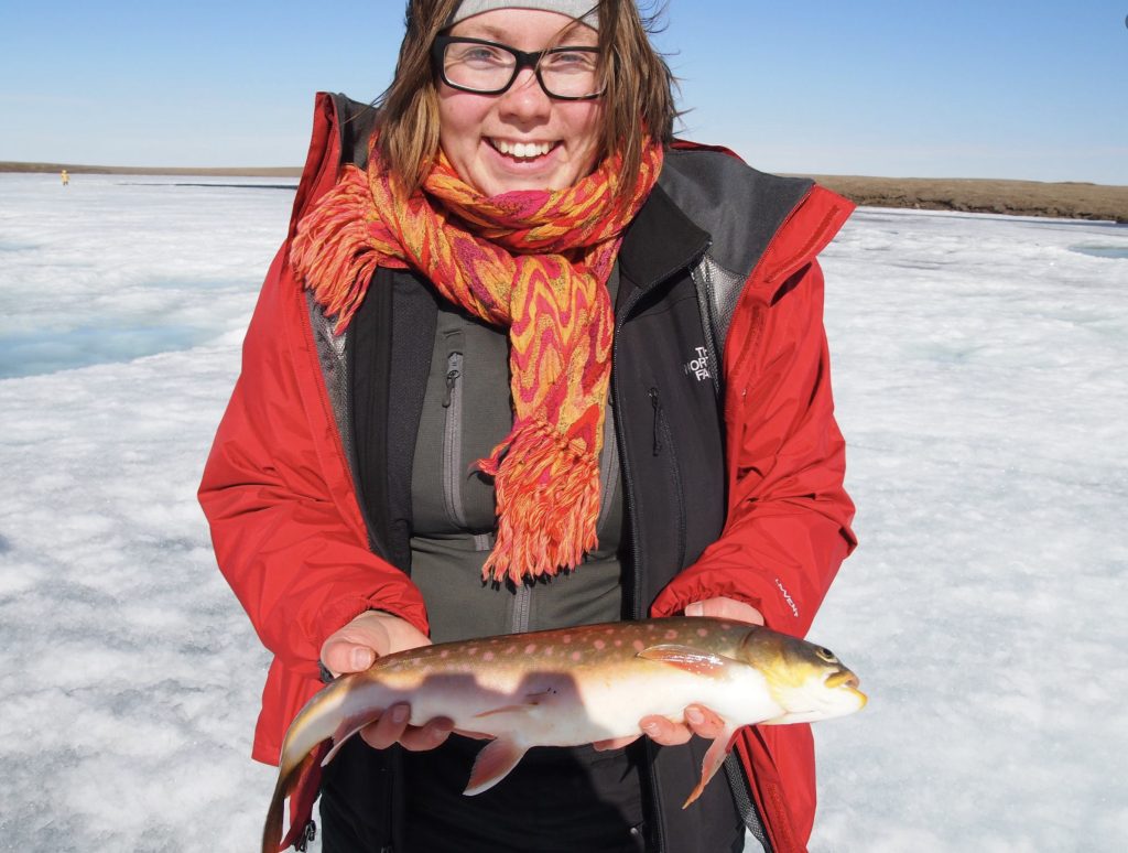 Zoe Todd, fish philosopher holding an Arctic char.